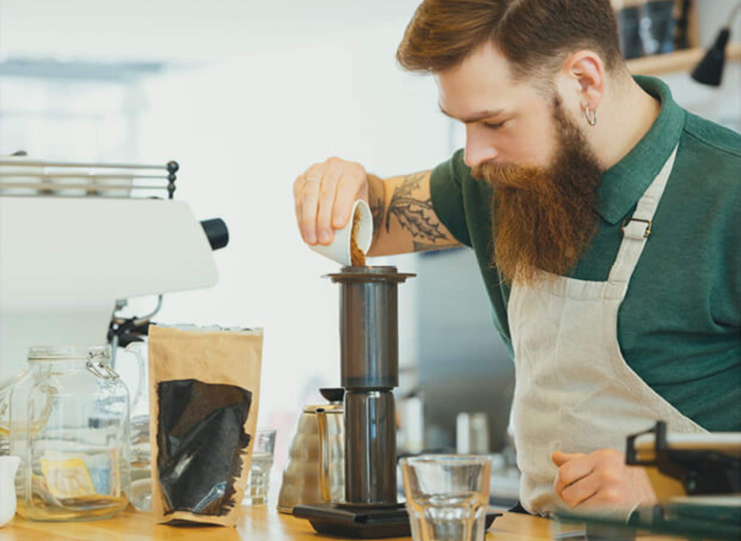 Man häller kaffe i en kvarn