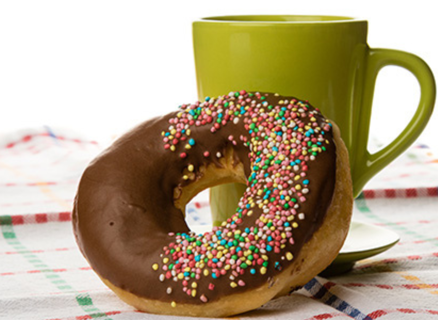 Donut på ett bord med grön kopp i bakgrunden