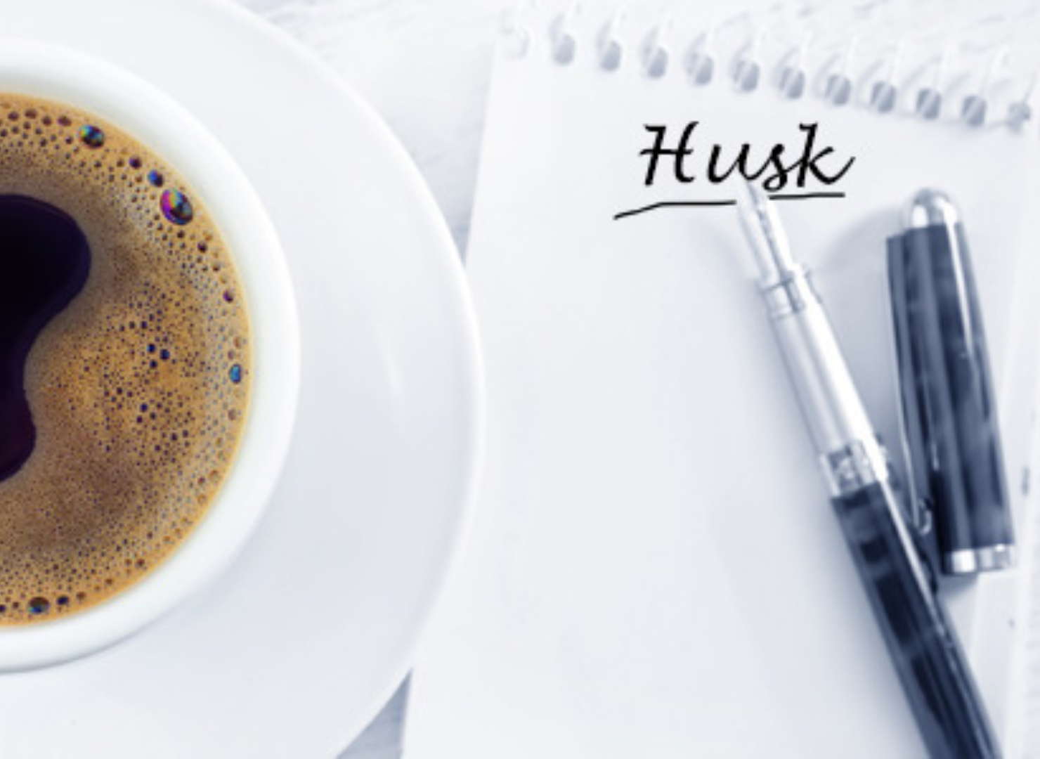 Kopp svart kaffe tillsammans med anteckningsblock