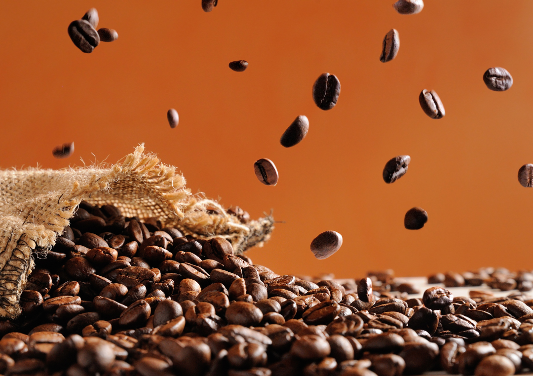 En påse kaffebönor hälls ut på ett bord
