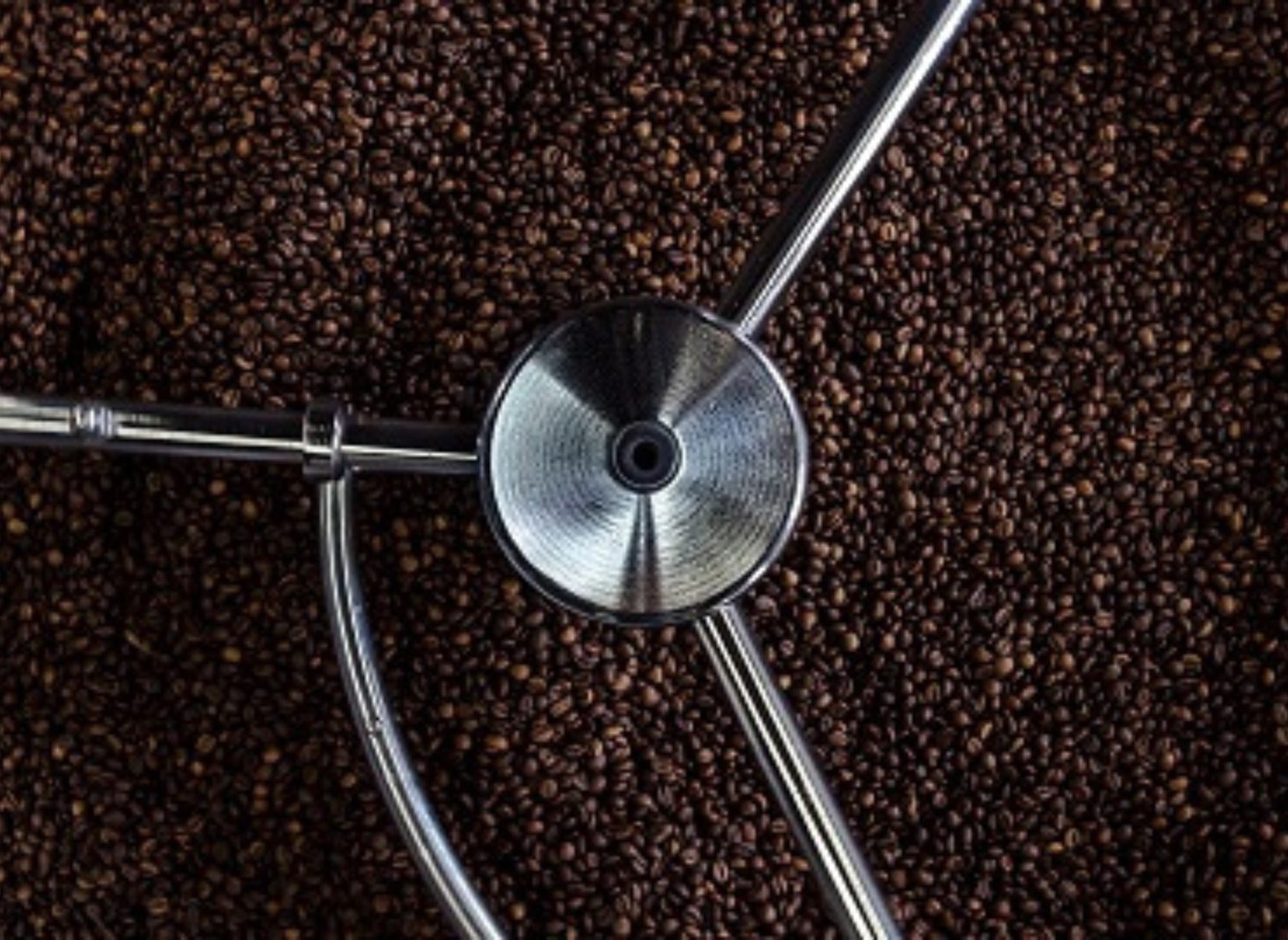 Kaffebönor i metallmaskin