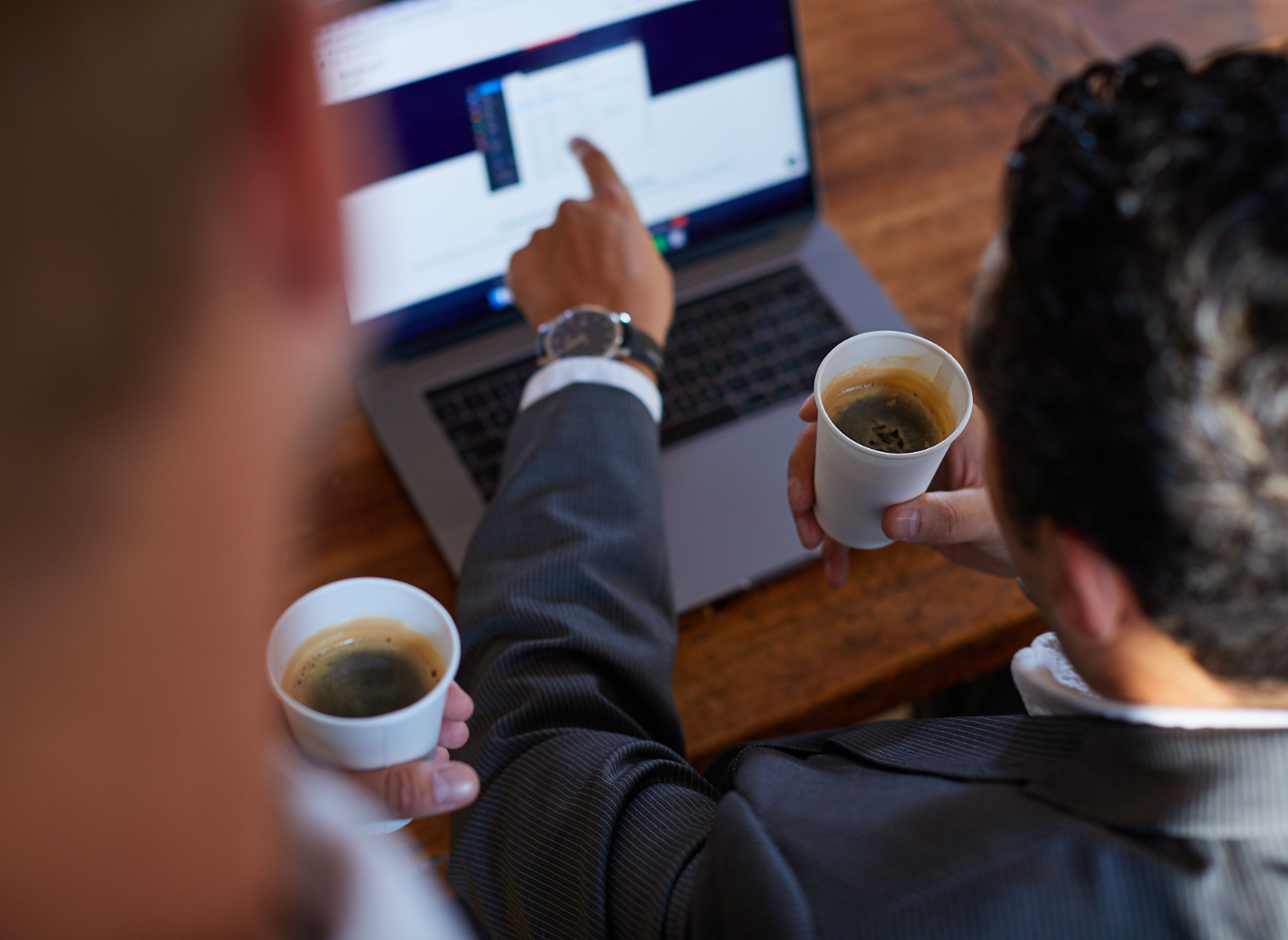 Man sitter med en kopp kaffe vid sin laptop